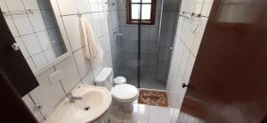 a small bathroom with a toilet and a sink at Casa de Campo em Monte Verde in Camanducaia