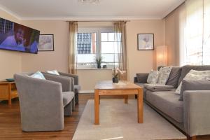 a living room with two couches and a table at Wodan, Whg 1 in Tinnum