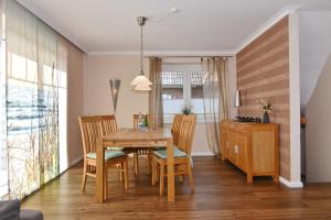 a dining room with a wooden table and chairs at Wodan, Whg 1 in Tinnum