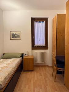 a bedroom with a bed and a window and a chair at Casa Alba sul Lago in Dervio +14 photos