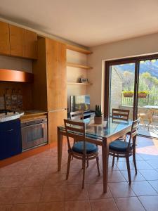 a kitchen with a wooden table and chairs and a table at Casa Alba sul Lago in Dervio
