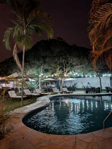 a swimming pool at night with tables and chairs at Tambo II Hotel Campestre in Cieneguilla