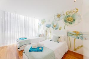 two beds in a room with flowers on the wall at BestVillas Park Ofir in Esposende +113 photos