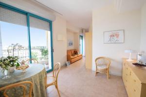 a living room with a table and chairs and a couch at Bellariva Feeling Hotel in Rimini