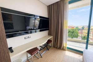 a room with a desk and a large window at Bellariva Feeling Hotel in Rimini