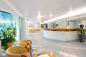 a lobby of a hospital with chairs and a bar at Bellariva Feeling Hotel in Rimini