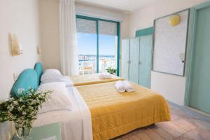 a bedroom with a bed with two towels on it at Bellariva Feeling Hotel in Rimini +52 photos