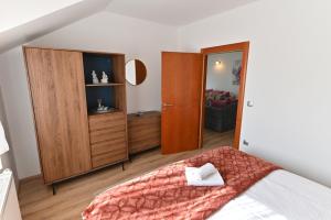 a bedroom with a bed and a wooden cabinet at Apartmani Lucija in Ludbreg