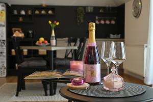a bottle of wine sitting on a table with glasses at Apartmani Lucija in Ludbreg +25 photos