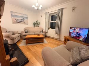 a living room filled with furniture and a flat screen tv at The Townhouse Dungloe in Dungloe
