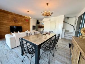 a dining room and living room with a table and chairs at Chalet César in Risoul
