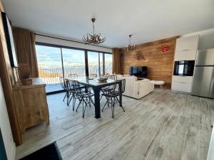 a kitchen and living room with a table and chairs at Chalet César in Risoul +6 photos
