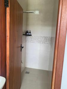 a bathroom with a shower with a white tiled floor at Kgcottage in Nairobi