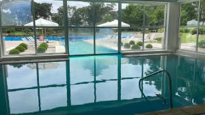a swimming pool with blue water and windows at Green Park Solanas Monoambiente Punta del Este in Punta del Este +7 photos
