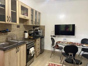 a kitchen with a sink and a table with chairs at Kgcottage in Nairobi +15 photos
