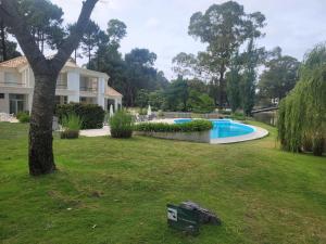 a house with a swimming pool in a yard at Green Park Solanas Monoambiente Punta del Este in Punta del Este