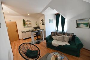 a living room with a green couch and a table at Apartmani Lucija in Ludbreg