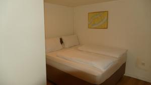 a small bed with white sheets and pillows in a room at Kapitänshaus Schäfer App Bootsmann in Brunsbüttel