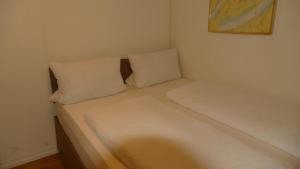 a bed with two pillows in a small room at Kapitänshaus Schäfer App Bootsmann in Brunsbüttel
