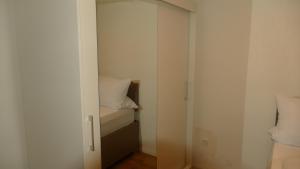 a small room with a closet with a bed at Kapitänshaus Schäfer App Bootsmann in Brunsbüttel +10 photos