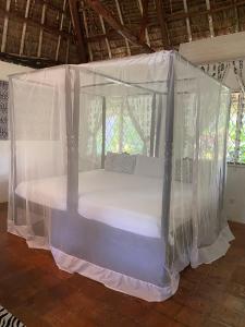 a bed covered in mosquito nets in a room at Sansuri Dreams Beach House in Msambweni +82 photos