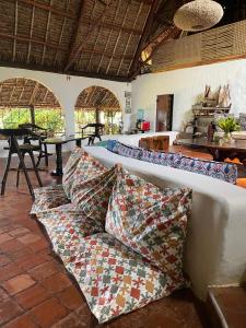 a couch in a room with a table and windows at Sansuri Dreams Beach House in Msambweni