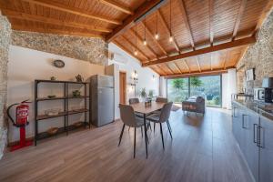 a kitchen and dining room with a table and a refrigerator at Casa da Portazinha - by Proguest in Amares
