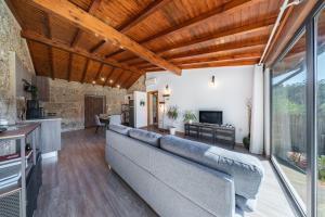 a living room with a couch and a television at Casa da Portazinha - by Proguest in Amares