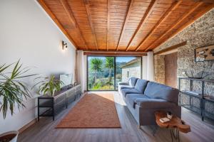 a living room with a blue couch and a large window at Casa da Portazinha - by Proguest in Amares +21 photos