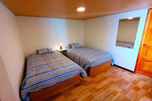 a bedroom with two beds and a mirror on the wall at Casa San Andres Hostal in Pasto