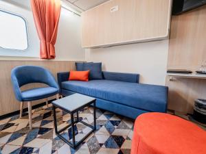 a living room with a blue couch and a chair at DFDS Ferry - Amsterdam to Newcastle in IJmuiden