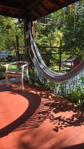 a bench sitting on a porch with a rope bridge at Pousada Maria de Lino in São Sebastião +3 photos