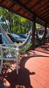 a hammock on a patio with a car parked at Pousada Maria de Lino in São Sebastião