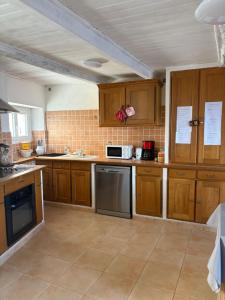 a large kitchen with wooden cabinets and appliances at Bella Vista Cabris in Cabris