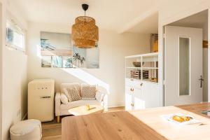a living room with a table and a chair at L'Embrun - Plage, port et marché à deux pas in Pornichet