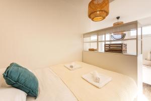 a bedroom with a bed with towels on it at L'Embrun - Plage, port et marché à deux pas in Pornichet