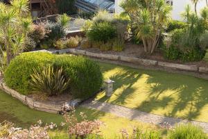 a garden with a pond with plants and trees at L'Embrun - Plage, port et marché à deux pas in Pornichet +4 photos