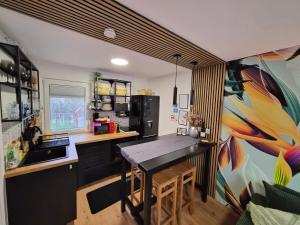 a kitchen with a table and a painting on the wall at Richland Ráckeve in Ráckeve