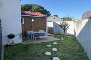 a small backyard with a table and a fence at Lodge La Forêt in Les Sables-d'Olonne