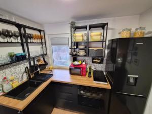 a kitchen with a black refrigerator and a wooden counter top at Richland Ráckeve in Ráckeve