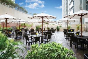 un ristorante con tavoli, sedie e ombrelloni di Harbour Plaza 8 Degrees a Hong Kong