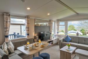 a living room with a couch and a tv at Finest Retreats - Pine Forest Lodge in Saint Enoder