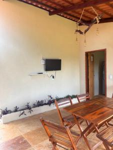 a dining room with a table and chairs and a tv at Casa Girasol in Trairi