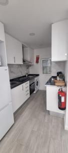 a kitchen with white cabinets and a stove top oven at Chinde Guesthouse in Lisbon