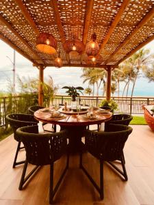 a dining room with a table and chairs on a patio at House Paraíso Flecheiras in Trairi