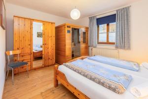 a bedroom with two beds and a chair at Am Rückerlhof in Waldmünchen