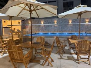 a group of tables and chairs with umbrellas on a patio at Hotel Chayrama in Santa Marta