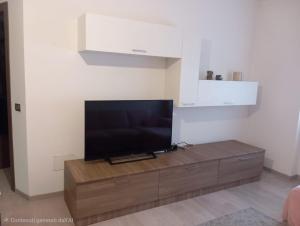 a flat screen tv sitting on top of a wooden entertainment center at Il Ciano in Sondrio +9 photos