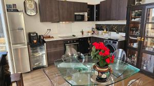 a kitchen with a glass table with red flowers on it at Chambre chez l'habitant Res Belle Epoque Ville d'hiver in Arcachon