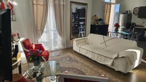 a living room with a white couch and a table at Chambre chez l'habitant Res Belle Epoque Ville d'hiver in Arcachon